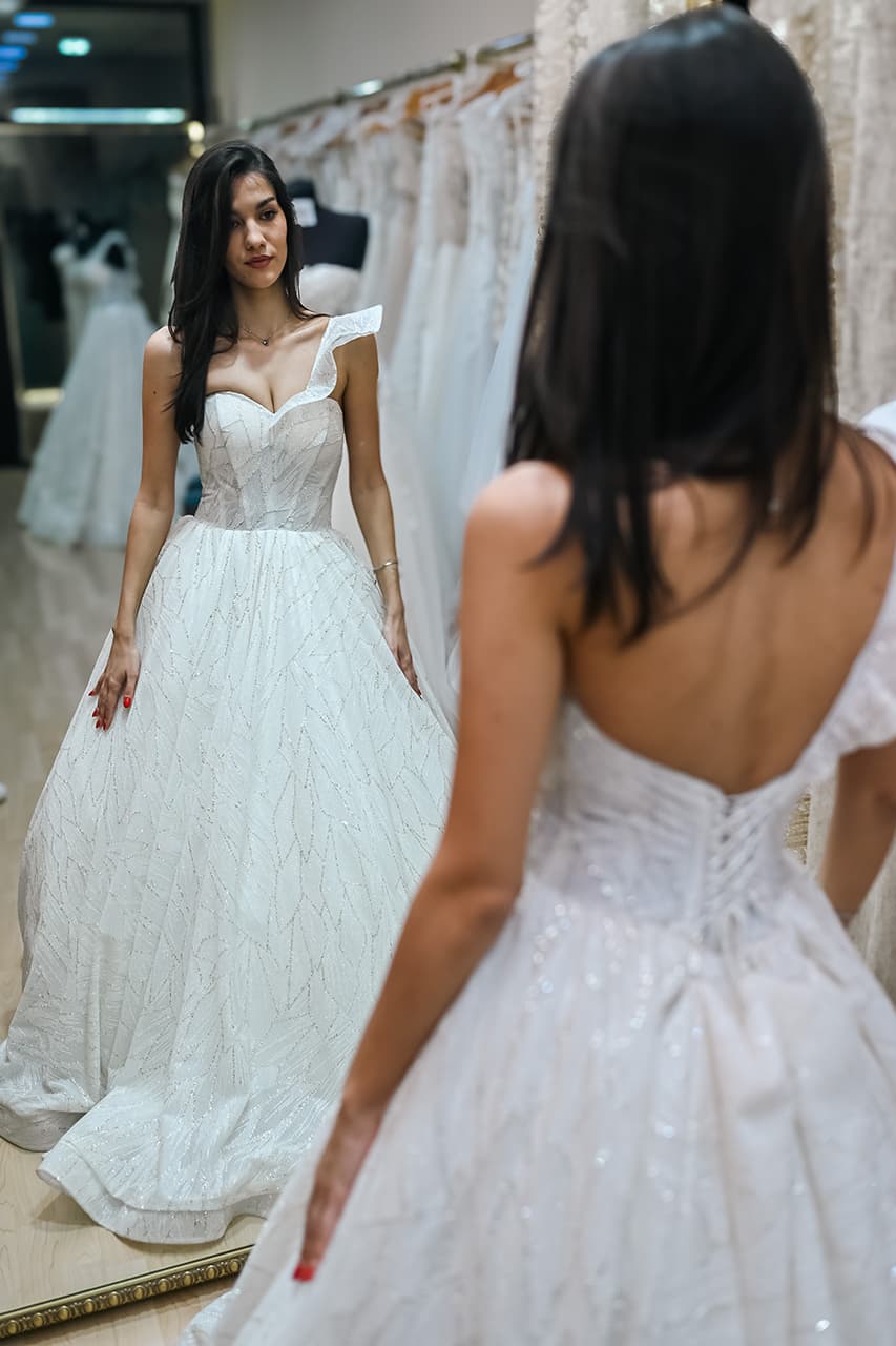 Mlada u venčanici sa jednim ramenom tokom probe ispred ogledala – Afrodita Beograd